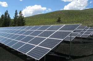 A set of solar panels in a field with a blue sky