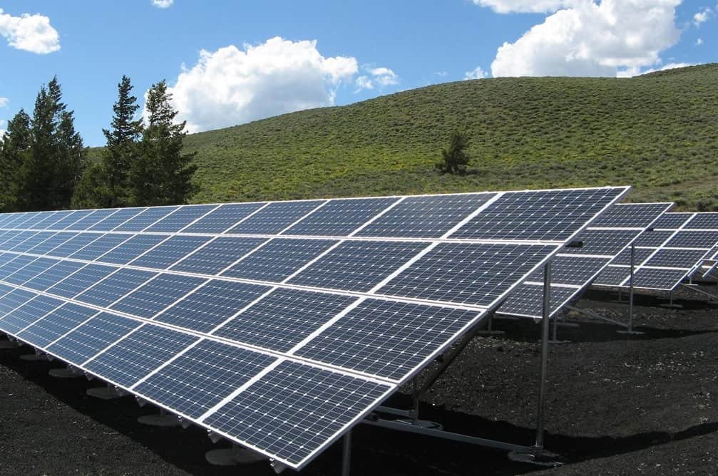 A set of solar panels in a field with a blue sky