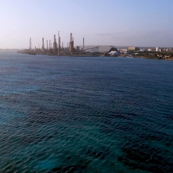 In the Middle East, an industrial facility with tall chimneys stands proudly near a wide expanse of blue water under a clear sky, showcasing advanced Toray membrane technologies.